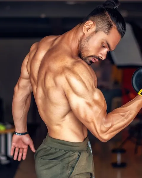 Indian man strength training with a dumbbell