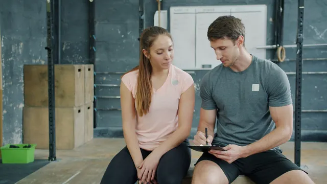 Trainer and client reviewing a workout plan in a gym