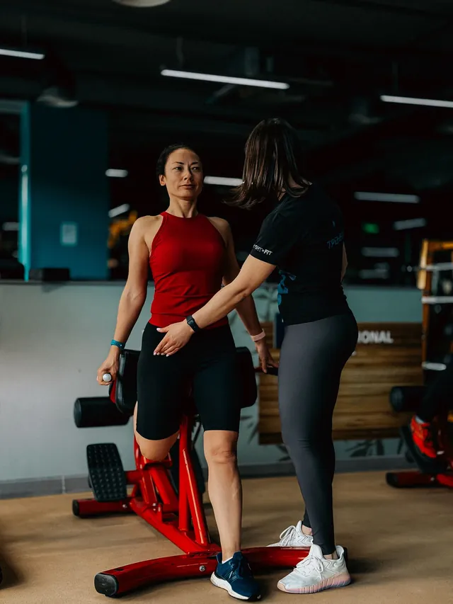 Trainer guiding a client through an exercise